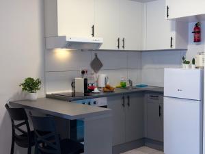 a kitchen with white cabinets and a white refrigerator at D' Suites Holiday Apartments in Il-Gżira +30 photos