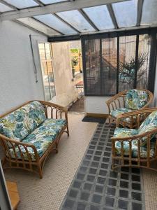 a porch with two wicker chairs and a window at Appartement centre ville in Châteauroux