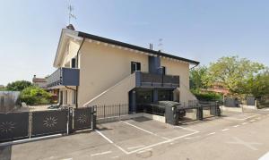 a building with a gate in a parking lot at La Casa di Nives in Scorzè
