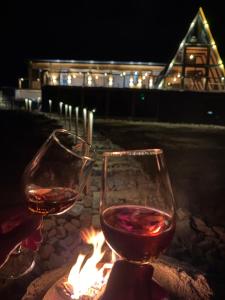 two glasses of wine sitting next to a fire at MonteRosso in Mărişel