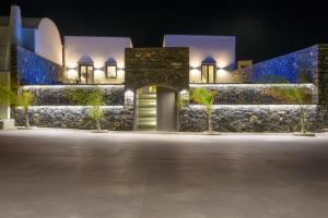 a building with a door in front of it at night at Koniko Santorini Private Pool Villas in Vóthon