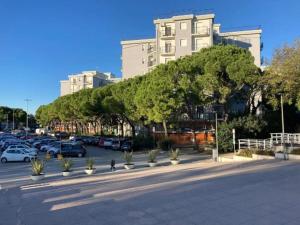 a parking lot with parked cars and a large building at JuliaHome in Marina Julia