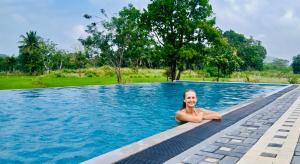 a woman laying in a swimming pool at The Wild Elephant Resort in Sigiriya
