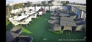 a row of tables and chairs on a balcony at Zora apartment in Rohtak