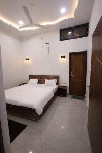 a bedroom with a large bed and a wooden door at Vrindavaneshwari Residence in Vrindāvan