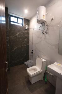 a bathroom with a toilet and a shower and a sink at Vrindavaneshwari Residence in Vrindāvan