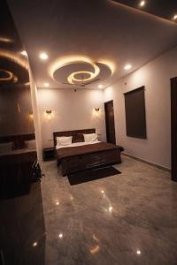 a large bedroom with a bed and a tv at Vrindavaneshwari Residence in Vrindāvan