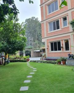 a building with a grass yard next to a building at Butsugen in Kathmandu