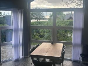 a table and chairs in front of a large window at Herning, Sunds Lake Beautiful View & Spa 105 m2 in Sunds