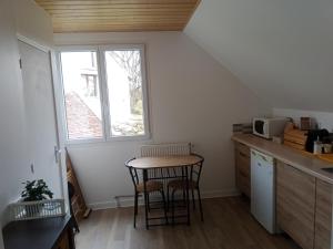 a small kitchen with a table and two chairs at Le relais Poyo in Arquian +27 photos