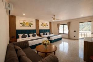 a hotel room with two beds and a couch at Riverline Gold Resort in Rishīkesh