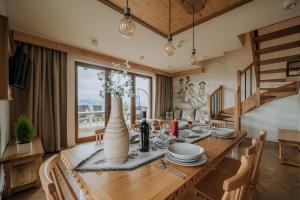 a dining room with a table with chairs and a large window at Osada Widokówka- Przystanek Podhale in Czorsztyn