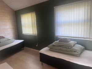 a bedroom with two beds and two windows at Herning, Sunds Lake Beautiful View & Spa 105 m2 in Sunds