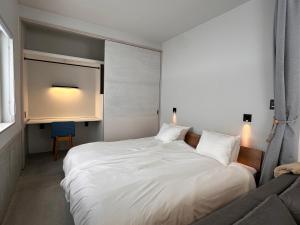 a bedroom with a large white bed and a couch at XYZ Niseko in Niseko