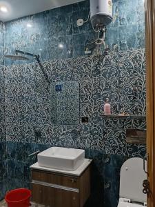 a bathroom with a sink and a blue tiled wall at Hotal zora in Rohtak
