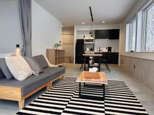a living room with a couch and a table at XYZ Niseko in Niseko +45 photos