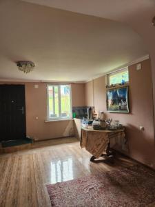 an empty living room with a table and a window at Iason Guest House in Mazeri in Mestia