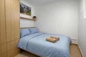 a small bedroom with a bed with blue sheets at Solange by Port Azur Rental in Cogolin