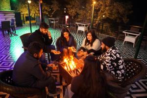 a group of people sitting around a fire at Riverline Gold Resort in Rishīkesh