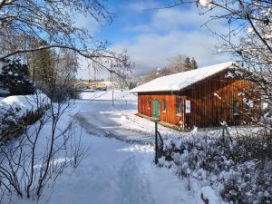 a small wooden cabin in the snow with a stream at Apartment Pool Sauna Netflix Bike Parking WIFI YTPremium in Zwiesel