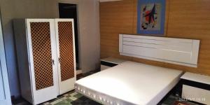 a bedroom with a white bed and a cabinet at A morada do peregrino in Poio
