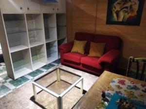 a living room with a red couch and a glass table at A morada do peregrino in Poio