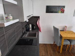 a kitchen with a sink and a wooden table at Apartment Pool Sauna Netflix Bike Parking WIFI YTPremium in Zwiesel +8 photos