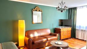 a living room with a leather couch and a television at Red Fox Apartment in Garmisch-Partenkirchen