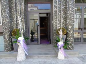 a front door of a building with purple and white bows at Hotel Airone in Trinitapoli