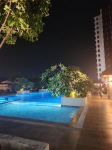 a swimming pool at night with two trees in it at AJB Royal Ocean Crest Mactan Cebu in Cebu City