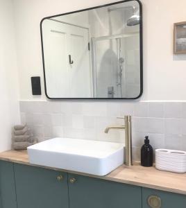 a bathroom sink with a large mirror above it at Manderley Cottage, Mousehole in Mousehole +35 photos