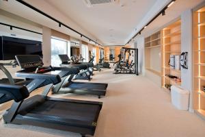 a gym with a row of treadmills and a row of treadleys at Hotel Molo Resort in Osiek