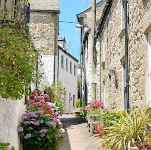 an alley with flowers in an old building at Manderley Cottage, Mousehole in Mousehole