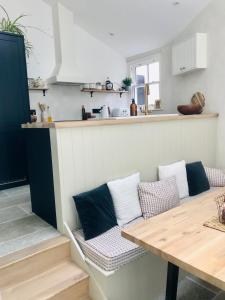 a living room with a table and a kitchen at Manderley Cottage, Mousehole in Mousehole