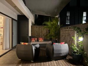a patio with two chairs and a table on a deck at Point de Mire in Rivière Noire