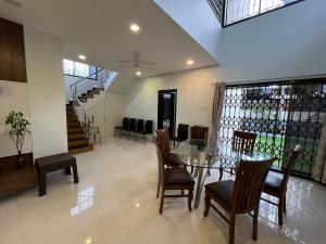a dining room with a glass table and chairs at Aarna Villa nr Valvan Dam in Lonavala