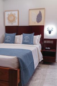 a bedroom with two beds with blue and white pillows at Elephanto Hotel LTD in Zanzibar City