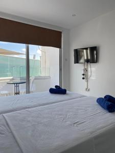 a bed with two blue pillows on top of it at Midtown Napa Apartments in Ayia Napa