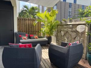 a patio with two chairs and a couch on a deck at Point de Mire in Rivière Noire