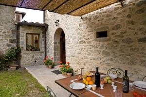 a table with fruits and wine bottles on a patio at La Casetta di Giovanni in Pratovecchio +11 photos