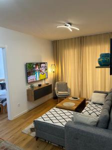 a living room with a couch and a tv at Apartman MAD Bjelasnica in Bjelašnica
