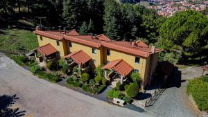 an aerial view of a yellow house with trees at Aphrodite's Inn Kalavrita in Kalavrita