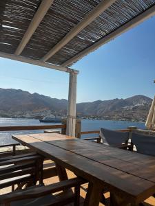 a wooden table on a deck with a view of the water at Astra Serifos in Livadi