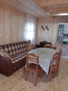 a living room with a couch and a table and chairs at Дом в Бахмаро in Chʼkhakoura