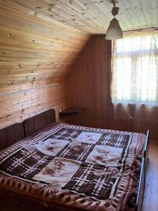 a bed in a room with a wooden ceiling at Дом в Бахмаро in Chʼkhakoura
