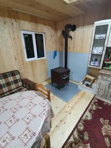 a room with a bed and a wood stove at Дом в Бахмаро in Chʼkhakoura +9 photos
