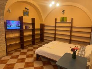 a room with a bed and a tv and a table at Срібний ключ in Mukacheve