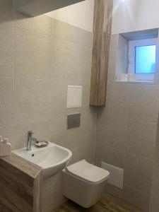 a bathroom with a white toilet and a sink at Срібний ключ in Mukacheve