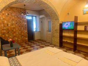 a room with a tv on a wall and a table at Срібний ключ in Mukacheve