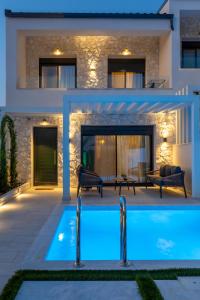 a villa with a swimming pool in front of a house at Bela Villas in Kallithea Halkidikis